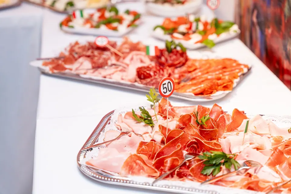 Silberne Platten mit hauchdünnem Schinken und Salami am Buffet
