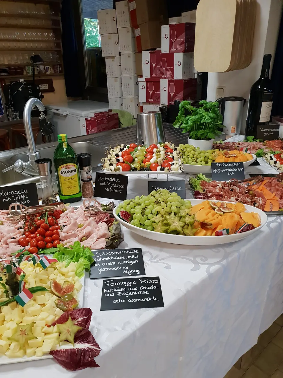 Buffet mit Antipasti-Schalen, Käse und Kreidetafeln, die die Gerichte beschriften