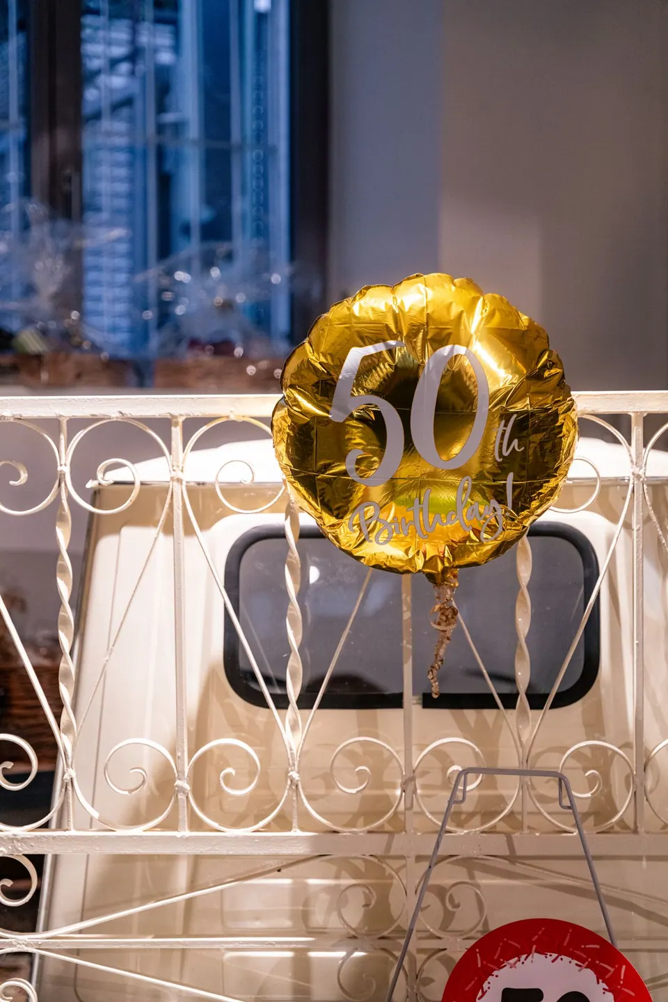 Eine weiße Ape mit goldenem Geburtstagsballon