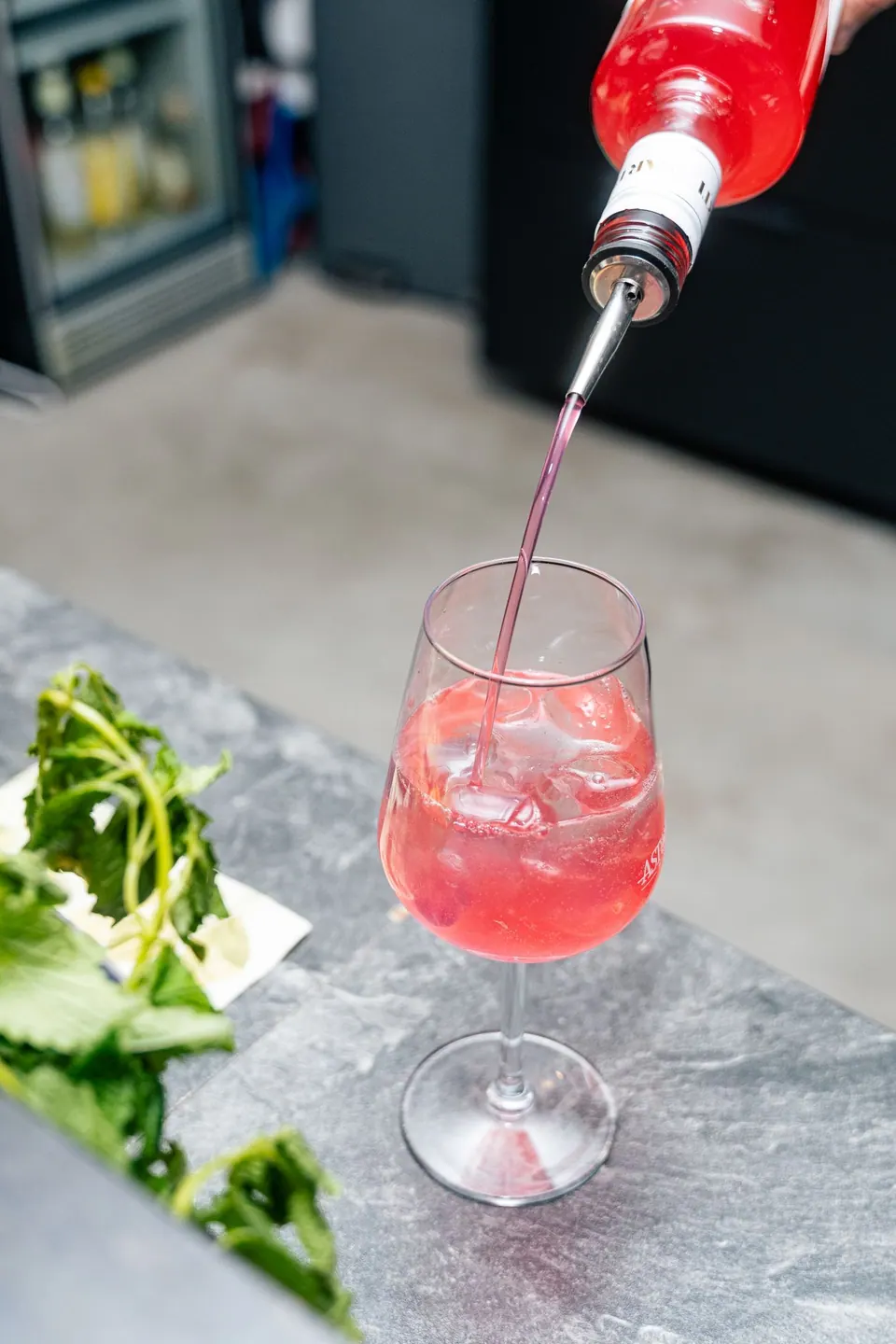 Ein Spritz wird an der Bar ins Weinglas eingeschenkt