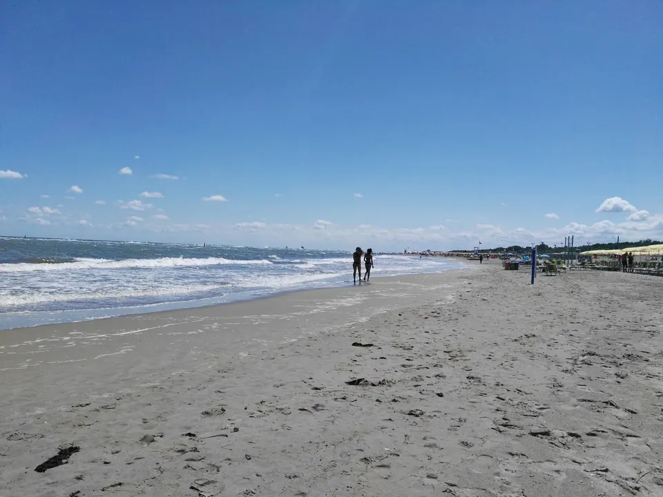 Weiter Sandstrand von Punta Marina mit Spaziergängern