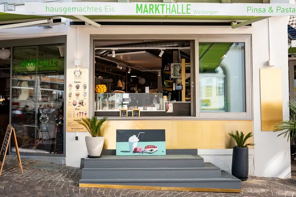 Das Eisfenster der Markthalle zum Marktplatz unter grüner Markise mit dem Schriftzug Markthalle und hausgemachtes Eis