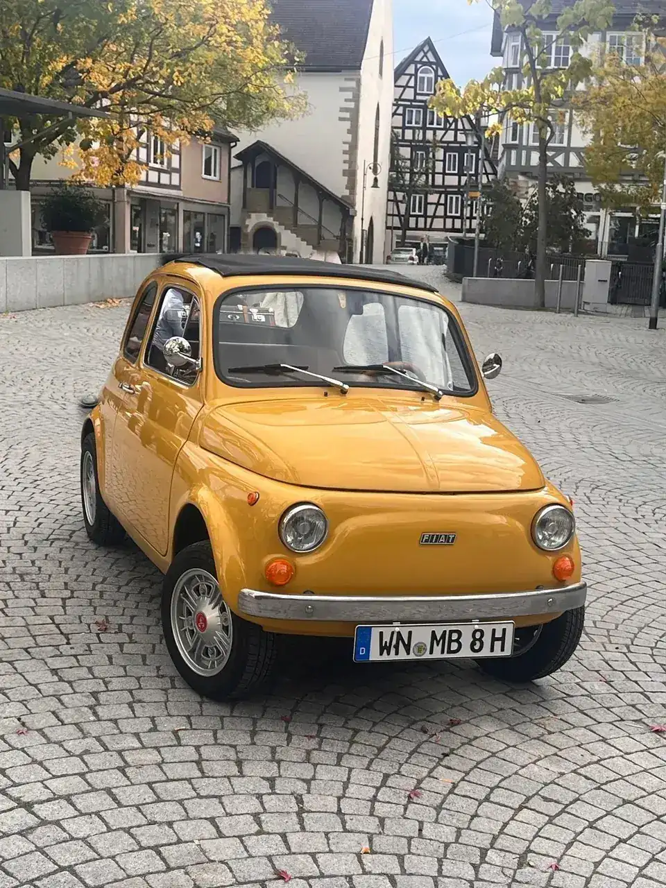 Der gelbe Fiat 500 der Familie auf dem Marktplatz